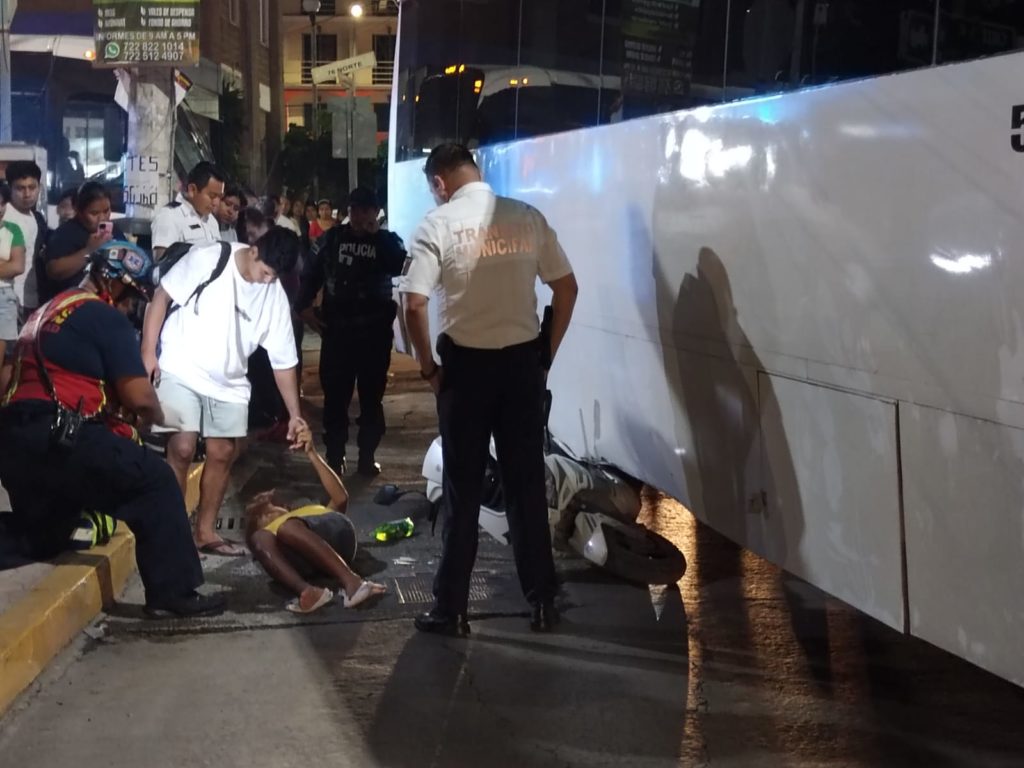 Termina motocicleta debajo un autobús Del Valle; trasladan a una persona al hospital